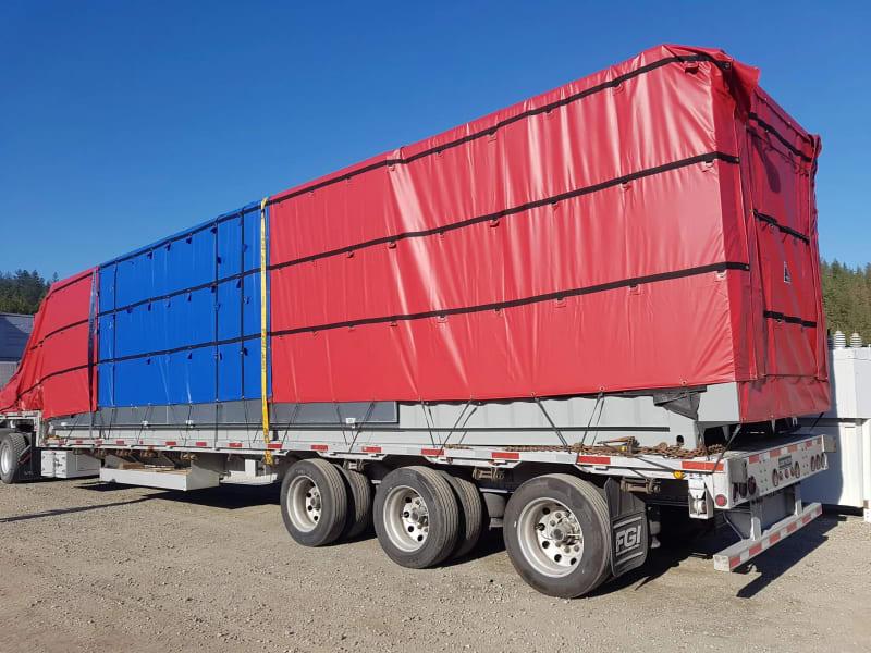 A blue and red tarp covering freight on a truck.