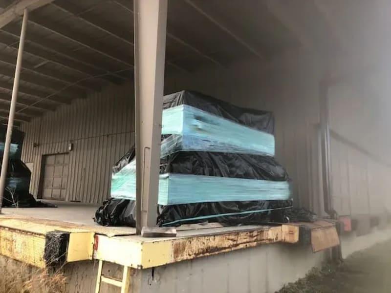 A wrapped tarp sits at a loading dock.