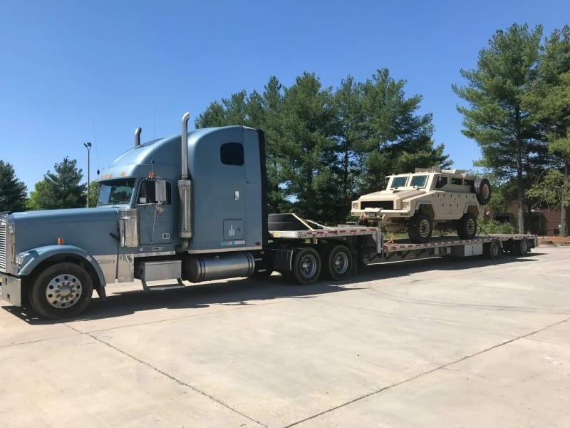 A Mamba military vehicle sitting on a truck's bed.