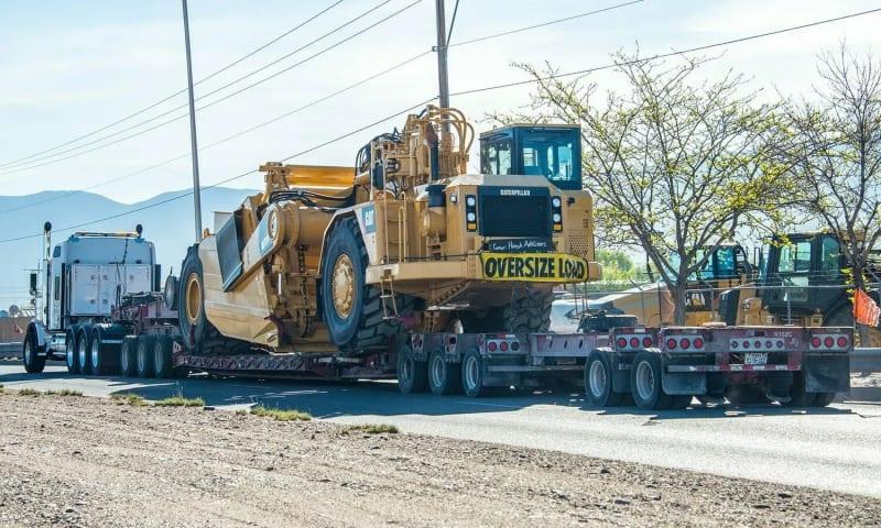 An alternate angle of the CAT equipment on a truck bed from behind.