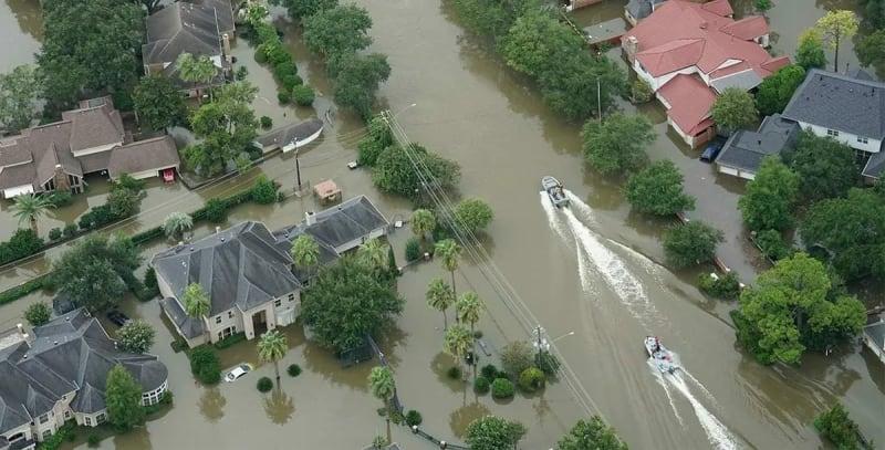 Overhead view of two boats navigating a flooded neighborhood.