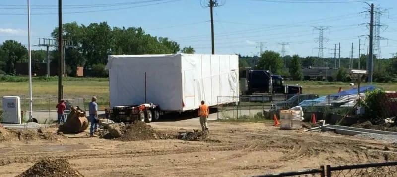 Another angle of a prefabricated building sitting on a truck at a job site