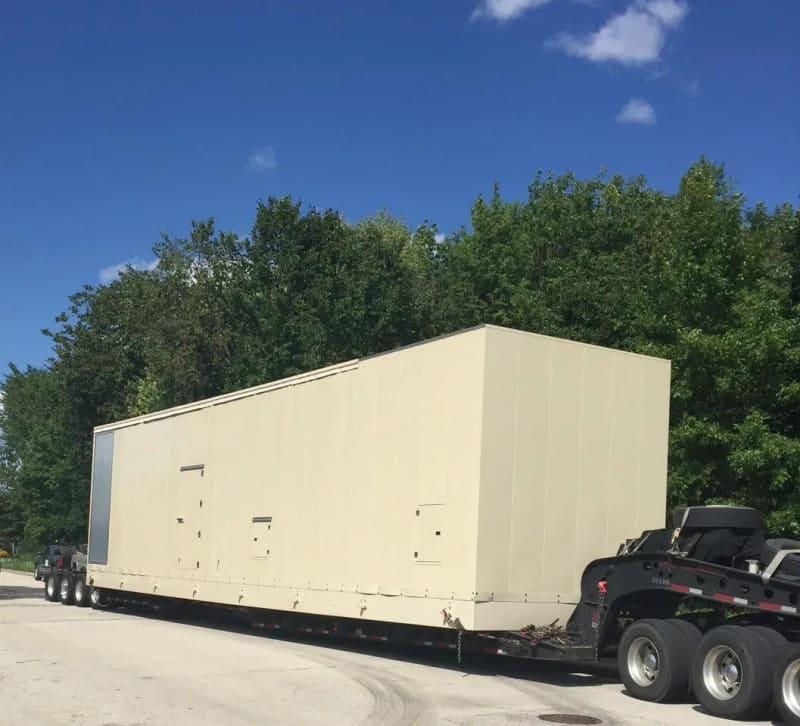 A generator enclosure sits on a truck bed.
