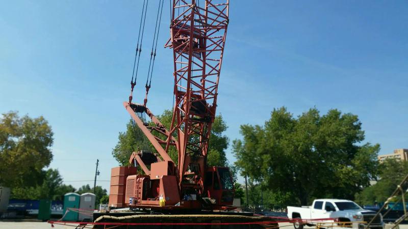 Another view of a red crane with its arm extended.