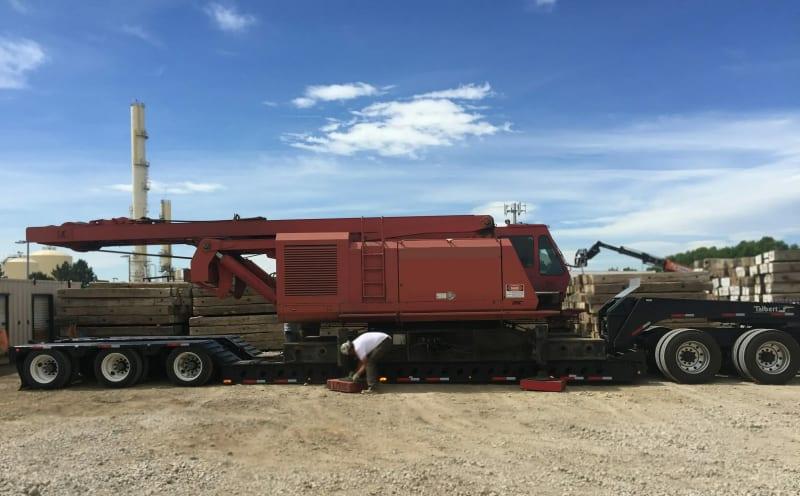 Pieces of a red crane loaded neatly onto a truck bed.