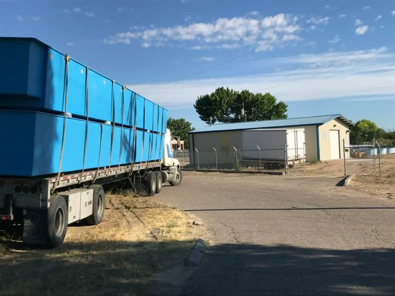 Two blue fish farms stacked onto a truck bed as the truck drives.
