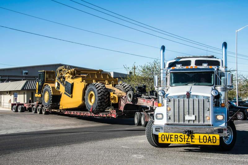 A yellow construction scraper on a truck