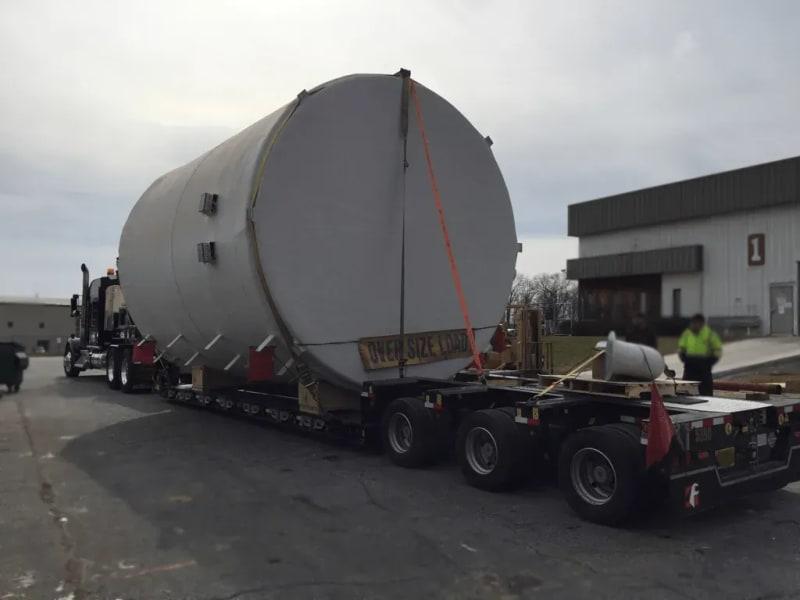The back of a truck carrying a white fiberglass tank.