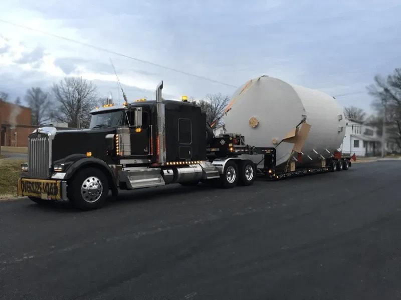 The side of a truck carrying a white fiberglass tank