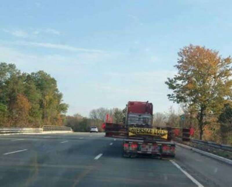 Concrete template rings sit on the back of a truck as it drives down a road.