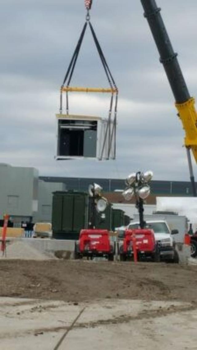 A crane lifting half of a prefabricated building
