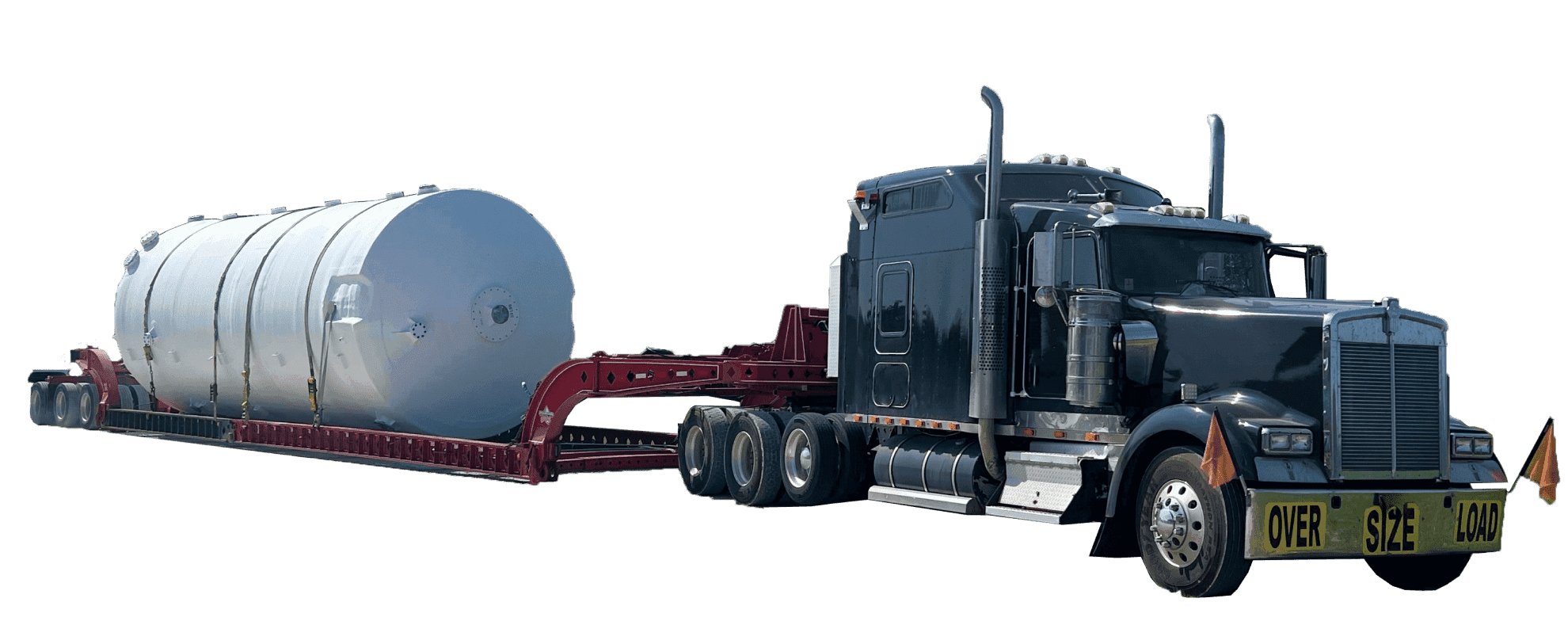 A side angle of a metal cylinder strapped to an oversized truck's low bed.