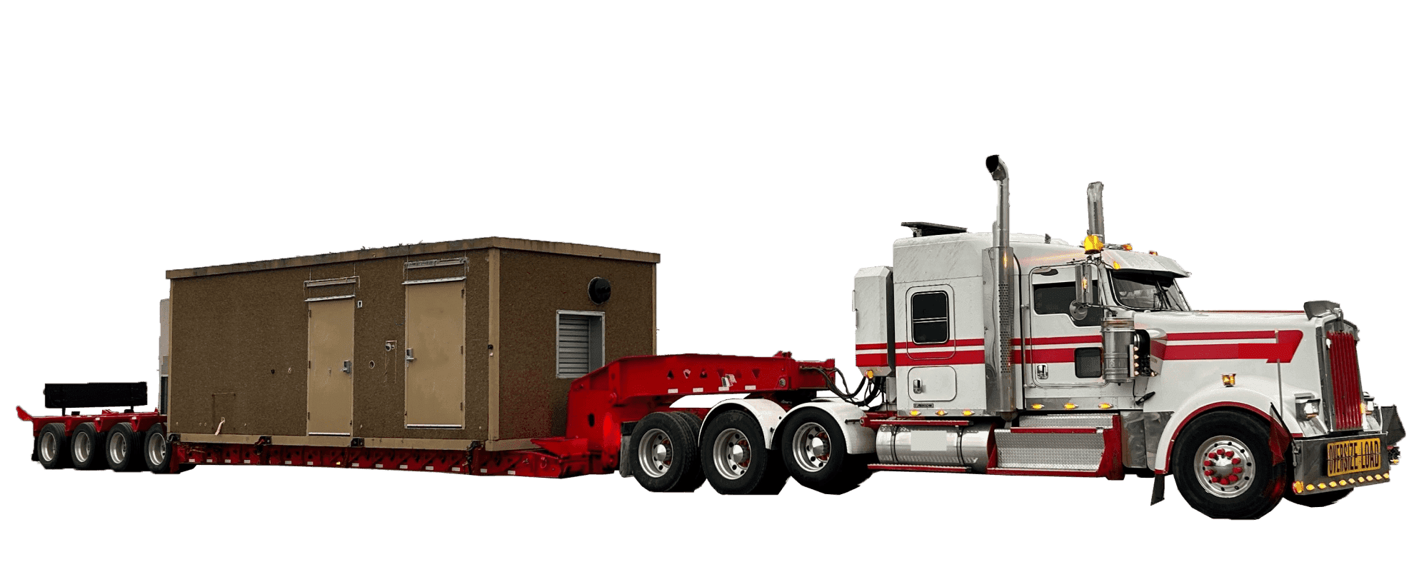 An overdimensional freight truck carrying a portable room on a low flatbed.