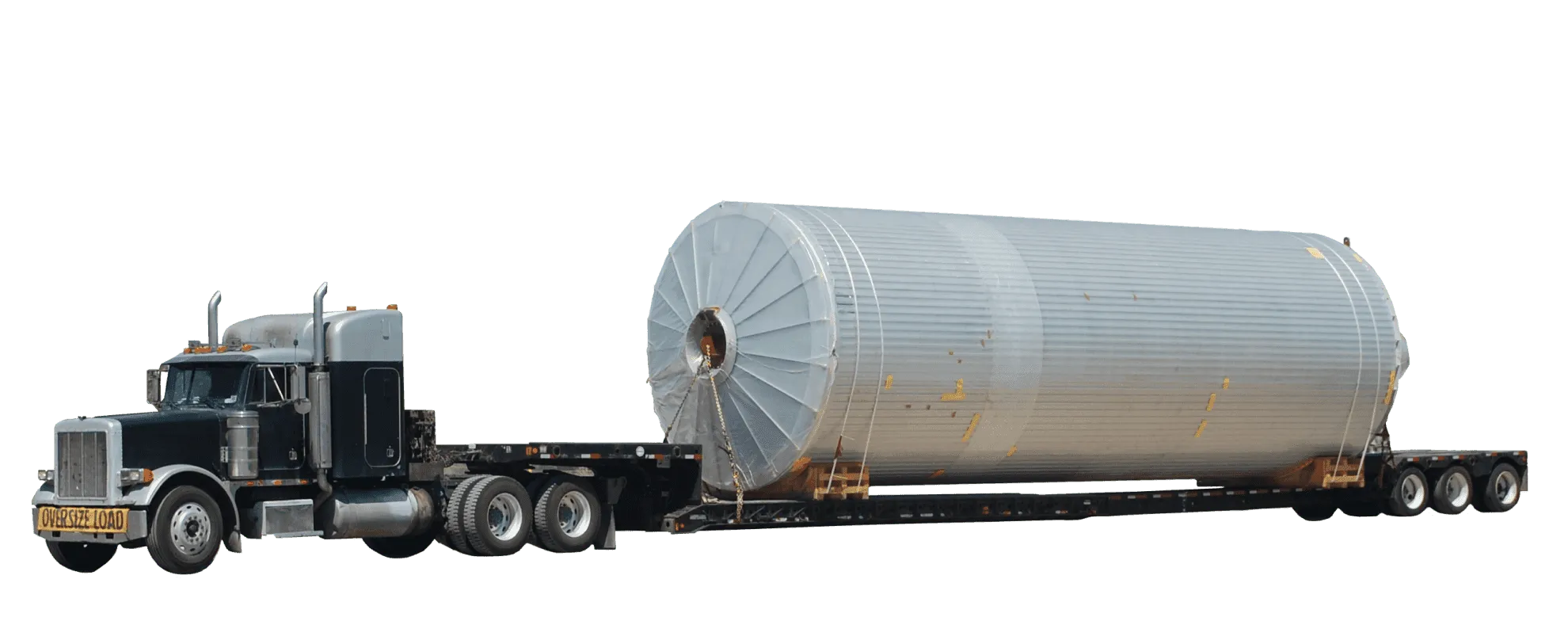 A side view of an overdimensional freight truck carrying an extremely oversized load on a low bed.